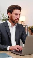 de edad mediana empresario a hogar oficina lee pagar cortar correo electrónico en ordenador portátil y suspiros después malo Noticias desafortunadamente. persona de libre dedicación chico a mesa frunce el ceño pensando acerca de salario cortar y siguiente pasos para cuentas presupuesto y alquilar. video