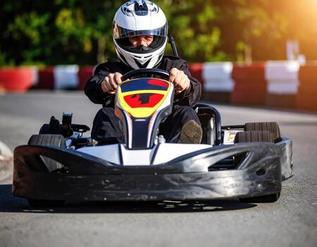 A man in a helmet driving a go kart photo