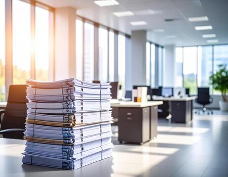 Stack of documents in an office with sunlight coming through the window photo