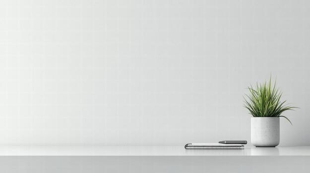 minimalist workspace featuring notebook and plant on desk photo