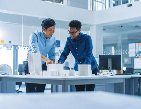 Collaborative teamwork in office setting showcases architect and team member discussing architectural models and designs, fostering creativity and innovation photo