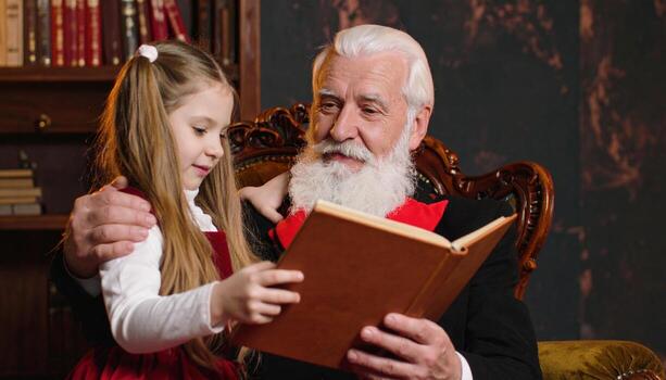 Old man reading to little girl in a library photo