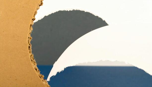 Close up of torn paper with layered colors and textures, creating abstract composition that emphasizes contrast and depth, evoking sense of curiosity and artistic expression photo