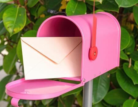 A pink mailbox with an envelope inside photo