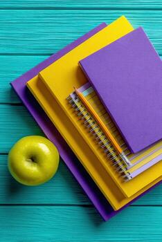 Stack of books and apple on table photo