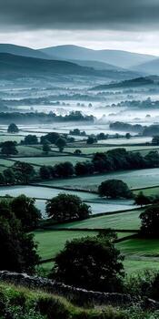 A misty landscape with green fields and hills photo