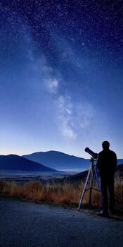 A man looks at the sky with a telescope photo