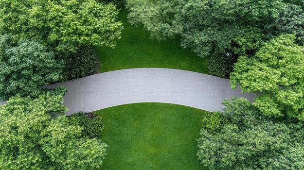 Curved pathway surrounded by lush greenery and trees creates serene atmosphere photo