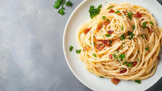 Creamy spaghetti carbonara with bacon bits garnished with parsley on white plate photo