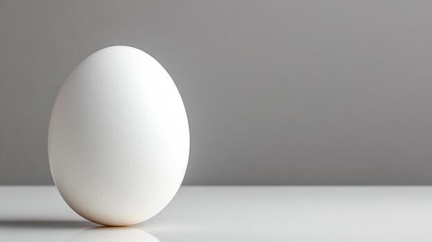 Single egg standing upright glossy white surface, showcasing its smooth texture and simplicity photo