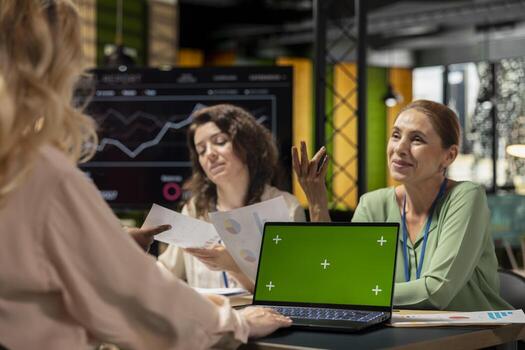 Team of goals oriented managers work with a chroma key screen on device in a modern boardroom, hosting a business discussion with monthly reports insight. Company strategy for growth. photo