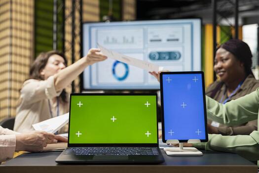 Diverse business associates using isolated display in modern office session, supporting digital planning and studying performance data reports. Strategic thinking and determination. photo