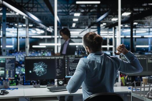 Data center engineer stretching at workstation to relieve back fatigue while using AI LLM assistant to perform maintenance. Server hub worker relaxing stiff back after long hours at computer photo