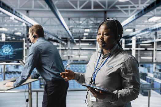 Data center admins conducting remote diagnostics with headset communication. Server hub coworkers interpreting artificial intelligence generated logs on tablet to resolve user issues photo