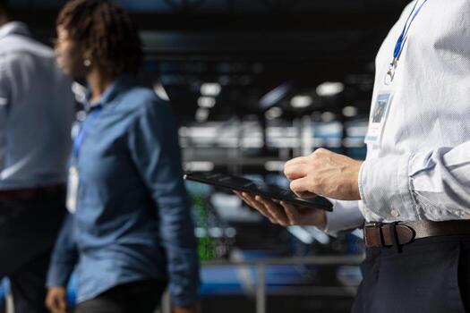 Server farm data scientist using tablet to review AI LLM visualization, intelligent systems for operational stability. Engineer analyzes neural network outputs for stable operations. photo