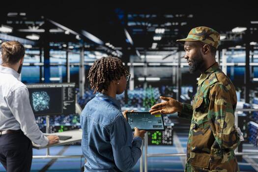 Military technicians in data center reviewing drone surveillance footage on laptop screen. Army unit officer in high tech server farm doing battlefield reconnaissance operations via drone control. photo
