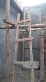 Wooden Ladder and Bamboo Scaffolding in Building Construction photo