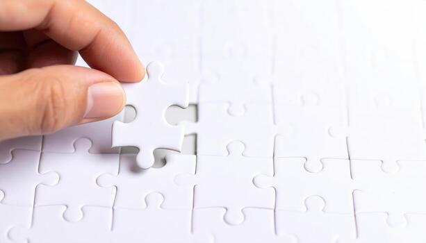 Macro close up of a hand placing a puzzle piece with copy space background, suitable for problem solving themes, teamwork concepts, strategy visuals, education projects, and creative solution design. photo