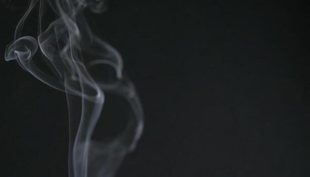 Close up of smoke rising against a black background with copy space, perfect for abstract design themes, atmospheric concepts, mystery visuals, dramatic texture projects, and creative art backgrounds. photo