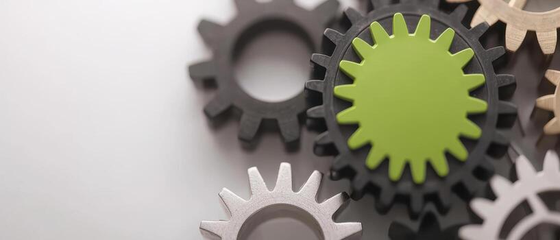 Abstract design of gears and machinery with green gear in center showing teamwork photo