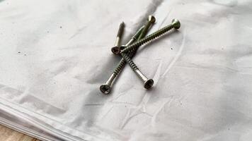 högen av skruvar anordnad ordentligt på arbete yta, verktyg för olika konstruktion uppgifter. fästelement bidra till varaktighet och stabilitet av projekt i Hem reparationer och renoveringar video