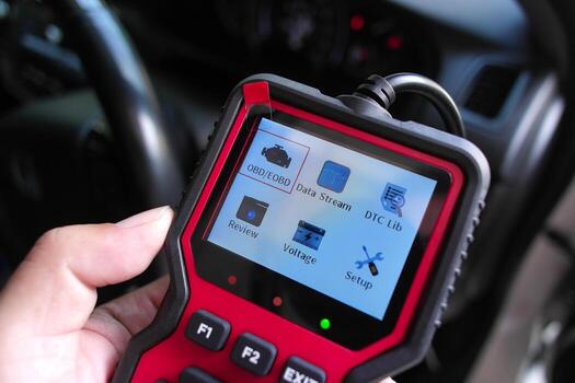 OBD2 scanner in hand, car diagnostic tool and code reader to check engine light, read and clear DTCs view live data and voltage photo