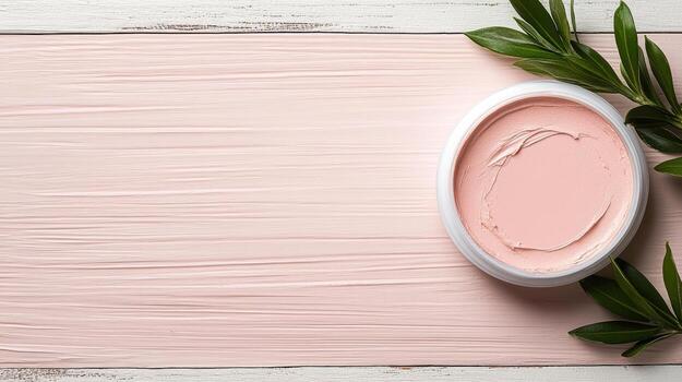 Creamy blush in round container on textured surface with green leaves photo
