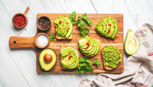 Artfully Arranged Avocado Toast Board with Fresh Sliced and Mashed Avocados, Spices, and Herbs. photo