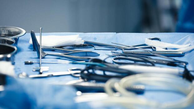 Surgical instruments arranged on a blue sterile table, showcasing various tools including scissors, forceps, and gauze, emphasizing the precision and care in medical procedures photo