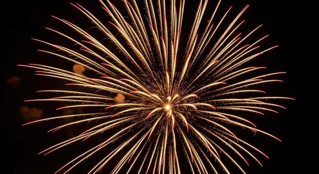 Spectacular golden and red fireworks exploding brightly in the dark night sky photo