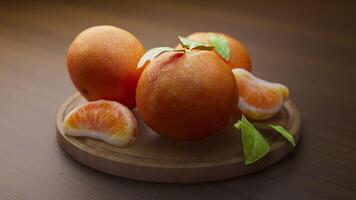 looping animering runt om en sammansättning av mandariner liggande på en trä- styrelse. slinga rörelse. oskärpa. video