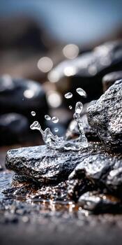 Water droplets create splashes on shiny rocks photo