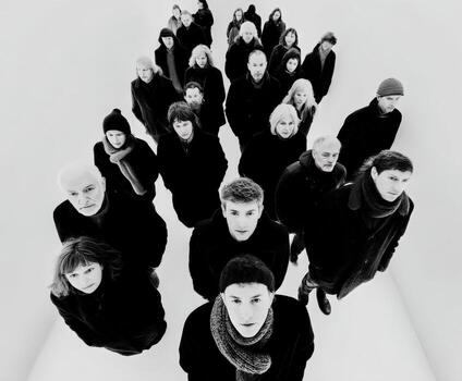 Looking up at the dark clothed crowd in black and white photo