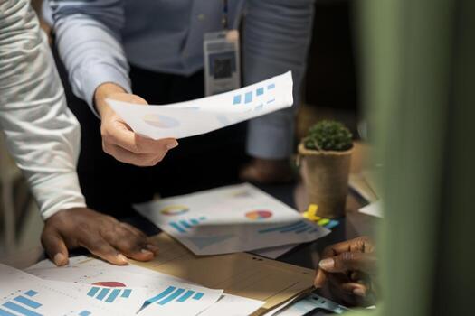Close up of professionals group evaluating files and performance indicators, using projections and diagrams to align the company objectives with shareholders expectations for company progress. photo