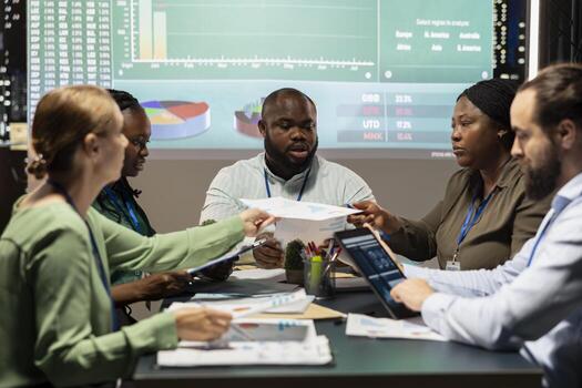 Multiethnic colleagues examining success and efficiency metrics within the firm, presenting project insight. Team members evaluating data reports and forecasts, productivity and progress. photo
