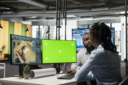 Black developers team preparing apartment building layout next to mockup screen, working at desk with dual monitors to design residential area after the construction project. Decorations software. photo