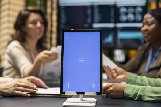 Diverse associates setting objectives with copy space display on tablet, empowering women creating projects through visuals, data driven planning and corporate innovation for growth. photo