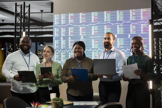 Portrait of multiethnic business team collaborating at night time, assembling in a dark office and working on global company development. Diversity within the advisory board group. photo