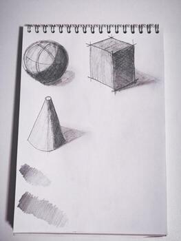 Sketching geometric shapes and shading techniques on spiral bound sketchpad photo