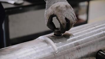 manutenção do óleo Produção equipamento. uma trabalhador dentro luvas parafusos a ganhar para dentro a furar. reparar do a óleo cano. video