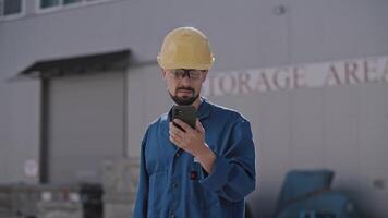 Construction worker using smartphone outdoors video