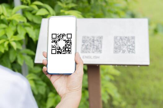 Hand holding smartphone with scanning QR code smart guide screen with guide for visitors sign photo