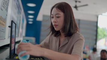 fångande en uppriktig ögonblick av en kvinna på en försäljning maskin väljer förfriskning under dagligen rutin- i en lokal- affär. video