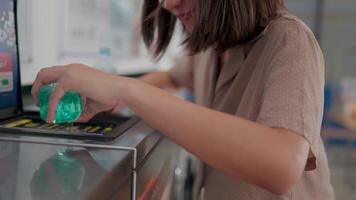 en kvinna interagerar med en dryck maskin tillsats en vibrerande grön is sfär skapande ett lockande visuell av förfriskning nöje och sommar vibrafon. video