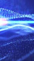Abstract blue wave of glowing digital particles creating a futuristic sense of flow and movement video