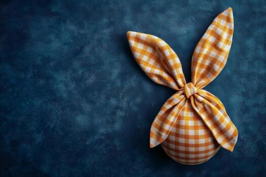 creativo decoración utilizando naranja comprobado tela a formar un conejito forma en un oscuro texturizado antecedentes foto