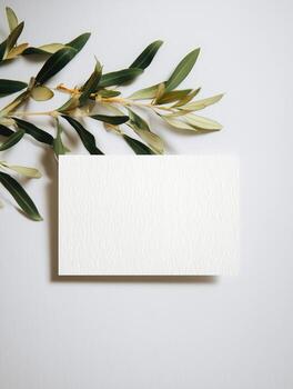Mockup of a boho invitation card on a minimalistic table with greenery photo