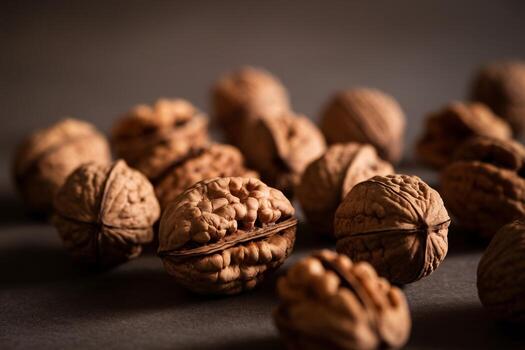 un de cerca de nueces dispersado en un oscuro superficie, destacando su texturizado conchas y natural patrones. foto