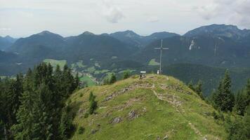 en korsa på topp av en berg med träd och bergen i de bakgrund video