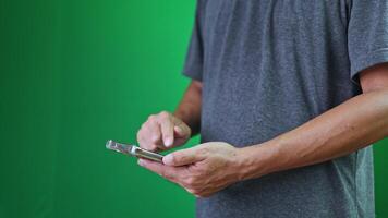 en man använder sig av smartphone i främre av grön skärm, som visar modern mobil användande, representerar digital kommunikation, teknologi, och modern anslutning video